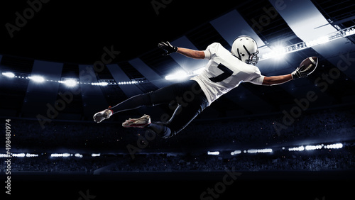 Collage with sportive american football player in action, catching the ball against night stadium with spotlights background. Back view