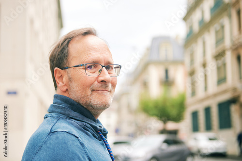 Outdoor portrait of middle age man on city street, wearing eyeglasses © annanahabed