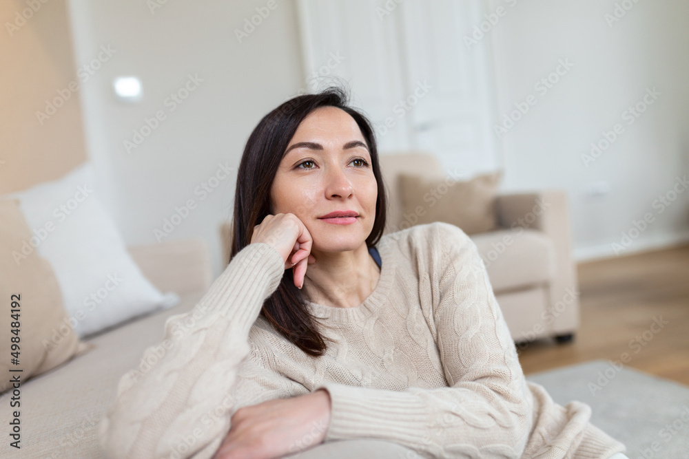 Portrait of smiling middle aged Asian woman looking at camera. Beautiful woman smiling at home.