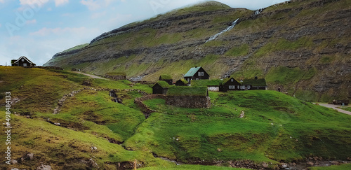 Spectacular view of the fairytale Saksun village in Faroe Islands.  Traditional green roof houses photo
