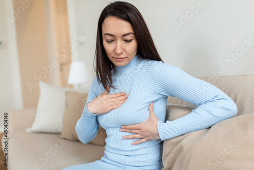 Asian Woman hand checking lumps on her breast for signs of breast cancer. woman is suffering from pain in the breast. BSE or Breast Self-Exam. Guidelines to check for breast cancer. photo