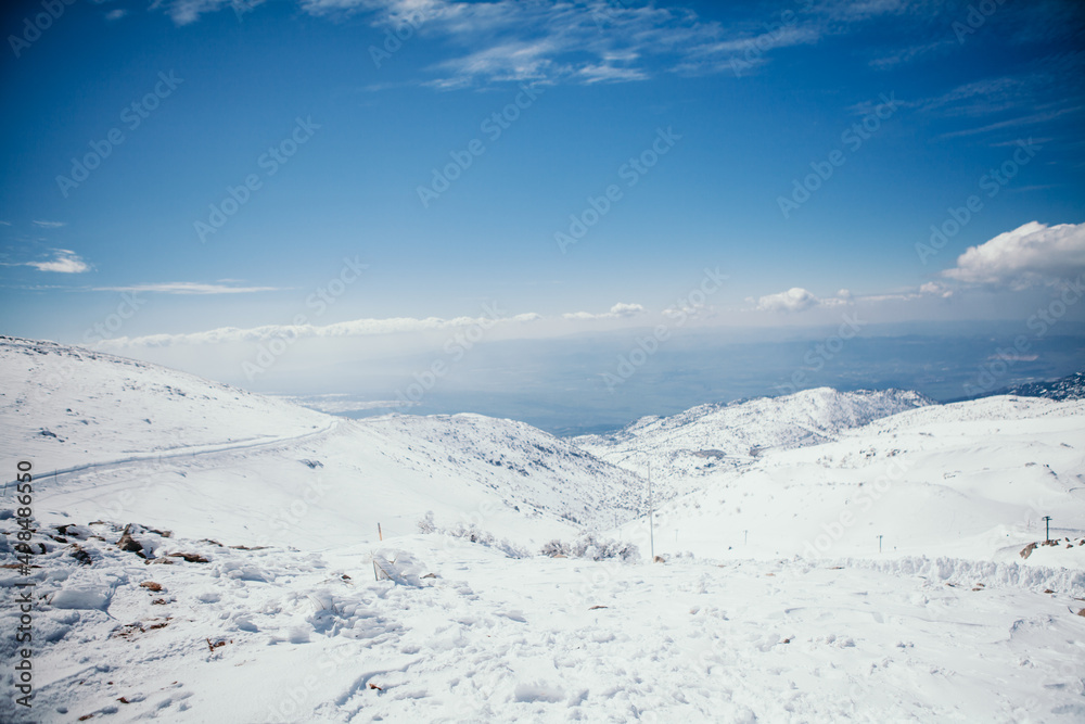 Panoramic view from highest point in Israel Mount Hermon. Winter day, Sun And Clouds, snow-capped mountains and Majdal Shams village on Golan heights Panoramic view from highest point in Israel Mount Hermon. Winter day, Sun And Clouds, snow-capped mountains and Majdal Shams village on Golan heights