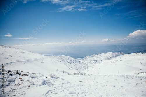 Panoramic view from highest point in Israel Mount Hermon. Winter day  Sun And Clouds  snow-capped mountains and Majdal Shams village on Golan heights