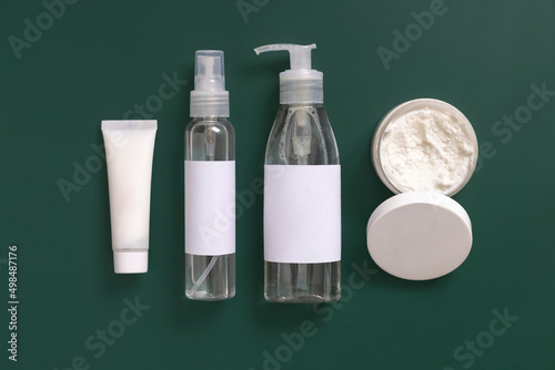 Homemade Cosmetics in plastic tubes and bottles on dark green top view. Brand packaging mockup. photo