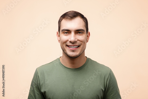 portrait of smiling man in green T-shirt on beige background, mockup © Руслан Галиуллин
