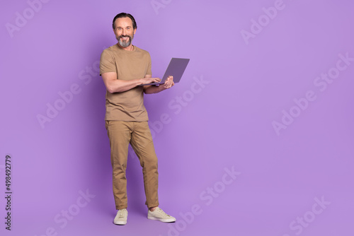 Full body photo of aged man use laptop manager expert boss project isolated over violet color background