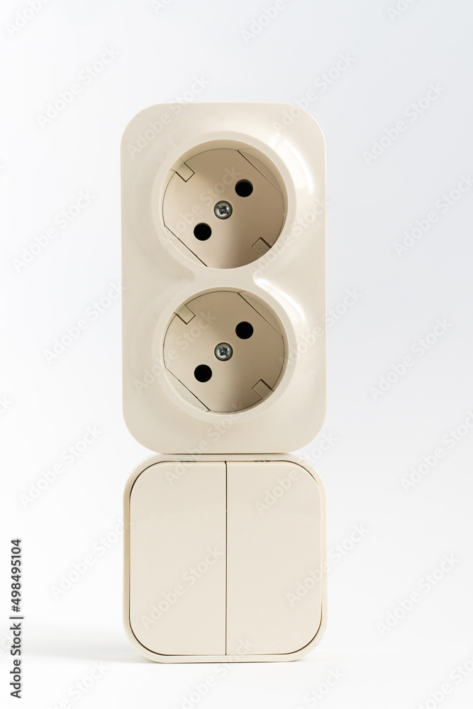 double socket and two-key light switch on white background. mechanical device for switching lighting circuit and two sockets connected by one monolithic case. shop of electronic devices for the home. double socket and two-key light switch on white background. mechanical device for switching lighting circuit and two sockets connected by one monolithic case. shop of electronic devices for the home.