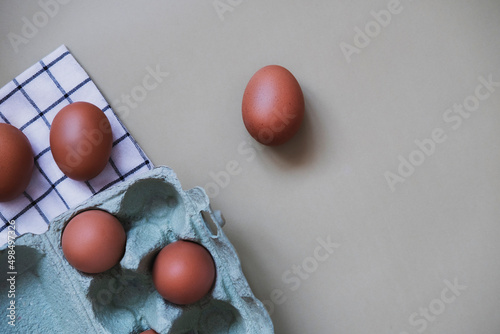 Chicken eggs in paper tray on light background. Concept farm products and natural nutrition. Top view, copy space, place for text.
