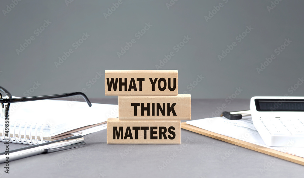 WHAT YOU THINK MATTERS text on wooden block with notebook,chart and calculator, grey background - obrazy, fototapety, plakaty 