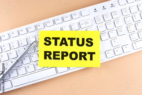 Text STATUS REPORT text on a sticky on keyboard, business concept photo