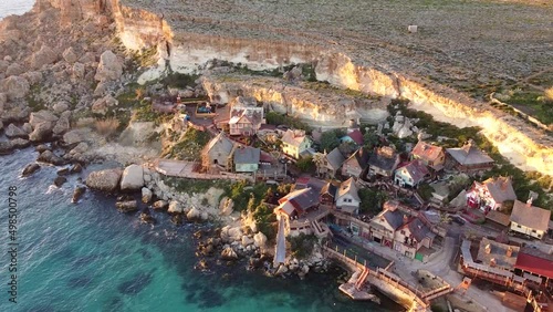 Wooden Popeye Village on rocky sea coastline, aerial view photo