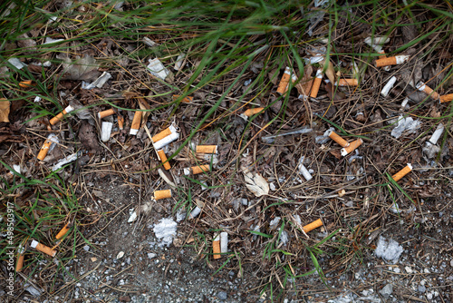 Cigarette butts pollution on floor in public park photo