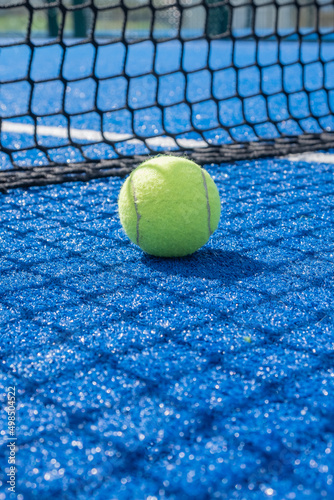selective focus, paddle tennis ball on a blue paddle tennis court close to the net, racket sports concept © Vic