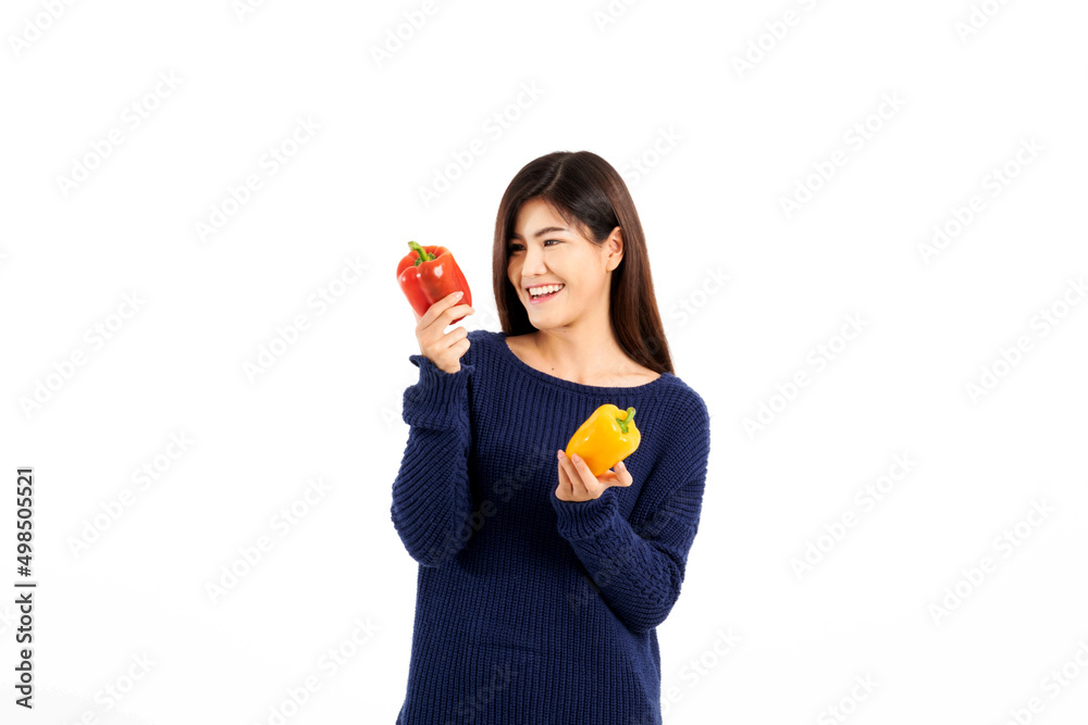 Portrait of a beautiful woman with long hair wearing a blue long-sleeve shirt holding colorful sweet peppers on a white background. Selective focus. Portrait of a beautiful woman with long hair wearing a blue long-sleeve shirt holding colorful sweet peppers on a white background. Selective focus.