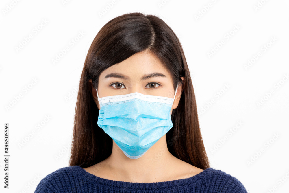 Portrait of a beautiful woman with long hair wearing a blue long-sleeved shirt and wearing a blue mask on a white background. Selective focus. Portrait of a beautiful woman with long hair wearing a blue long-sleeved shirt and wearing a blue mask on a white background. Selective focus.