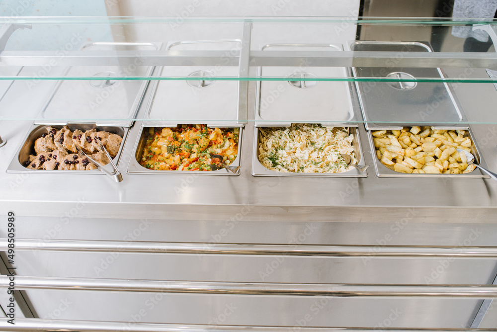 Different types of dishes in containers on the buffet table in the ...