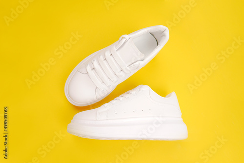 A pair of stylish women's leather shoes with laces (top view, side view) on a yellow background. Seasonal sales, promotions, discounts on casual shoes. Proper care for white skin.Copyspace