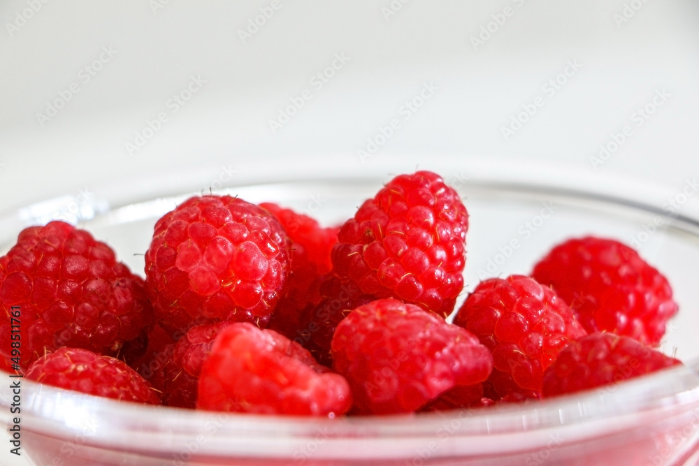 Close up or juicy and sweet raspberries in a glass bowl Close up or juicy and sweet raspberries in a glass bowl