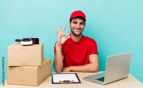 hispanic handsome man feeling happy, showing approval with okay gesture. packer employee concept photo