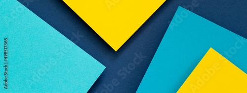 Abstract color papers geometry flat lay composition banner background with blue and yellow tones
