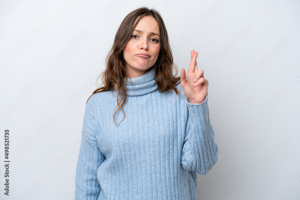 Young caucasian woman isolated on white background with fingers crossing and wishing the best Young caucasian woman isolated on white background with fingers crossing and wishing the best