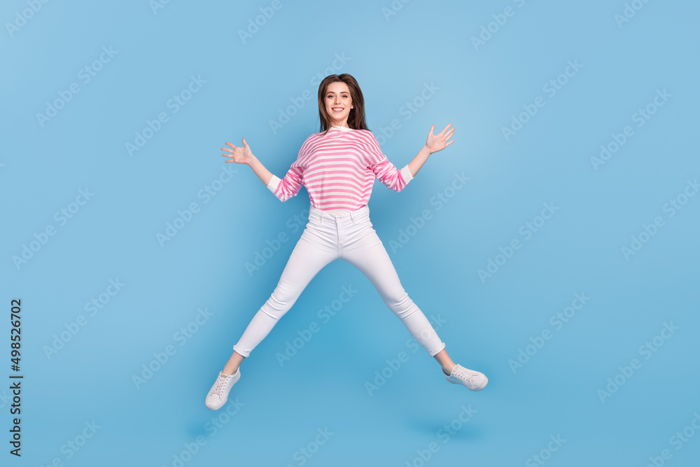 Full body portrait of satisfied cheerful person enjoy free time jumping isolated on blue color background