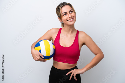 Young caucasian woman playing volleyball isolated on white background posing with arms at hip and smiling
