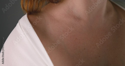 Attractive sexual woman covering her naked shoulder with white blouse, close up view