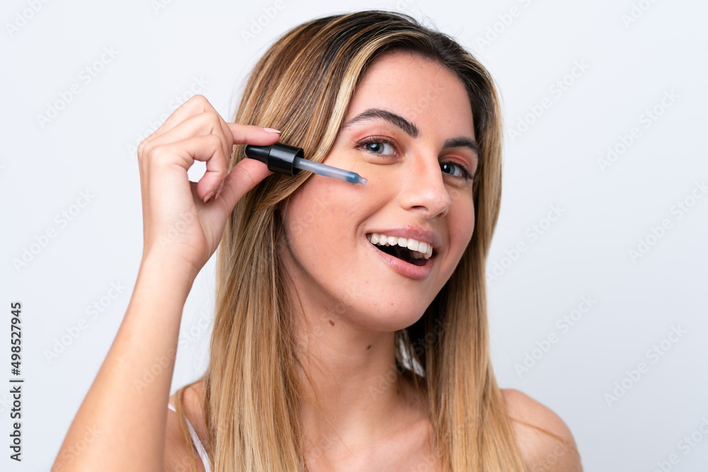 Young caucasian woman isolated on white background holding a serum. Close up portrait