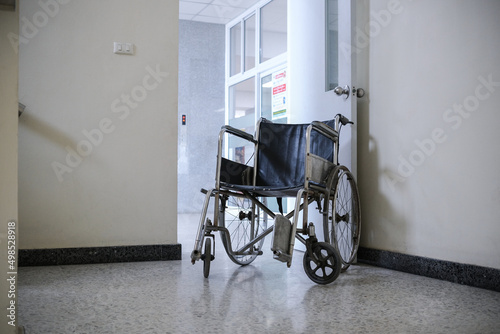 The wheelchair is located at the door inside the building in the hospital.