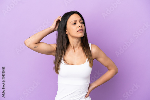 Young caucasian woman isolated on purple background having doubts while scratching head