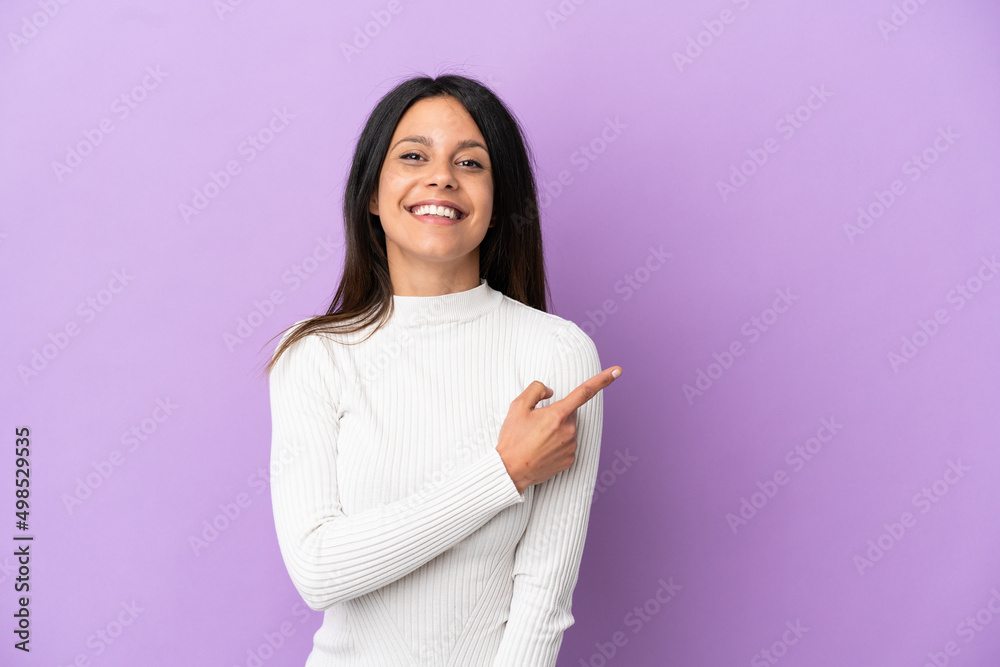 Young caucasian woman isolated on purple background pointing to the side to present a product Young caucasian woman isolated on purple background pointing to the side to present a product