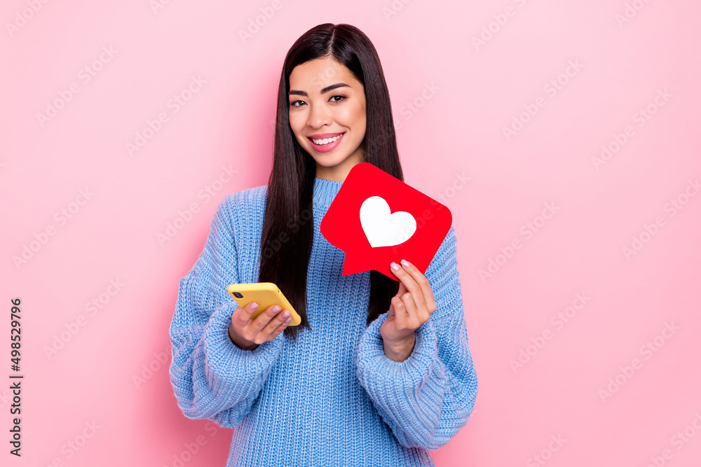 Portrait of beautiful trendy girl using device holding heart card smm post chat solution isolated over pink pastel color background Portrait of beautiful trendy girl using device holding heart card smm post chat solution isolated over pink pastel color background