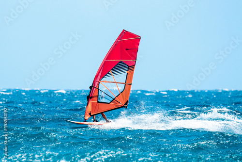 windsurfer have a fun riding the waves during a sunny summer day