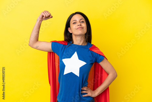 Fotobehang Woman isolated on yellow background in superhero costume and doing strong gestur