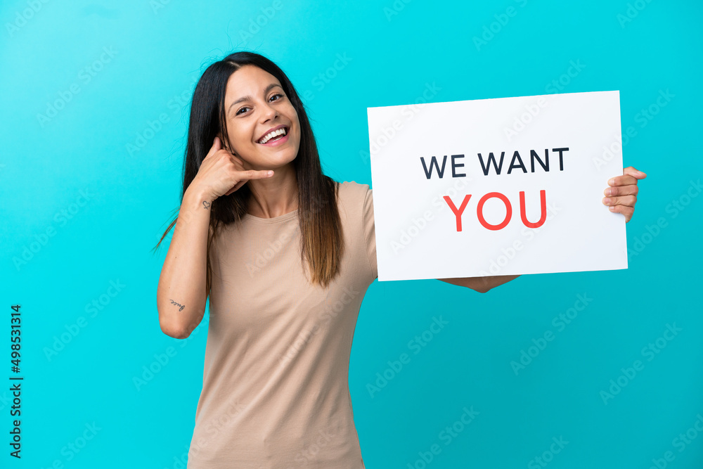 Young woman over isolated background holding We Want You board and making phone gesture Young woman over isolated background holding We Want You board and making phone gesture