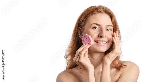Beautiful woman with makeup sponge on white background photo