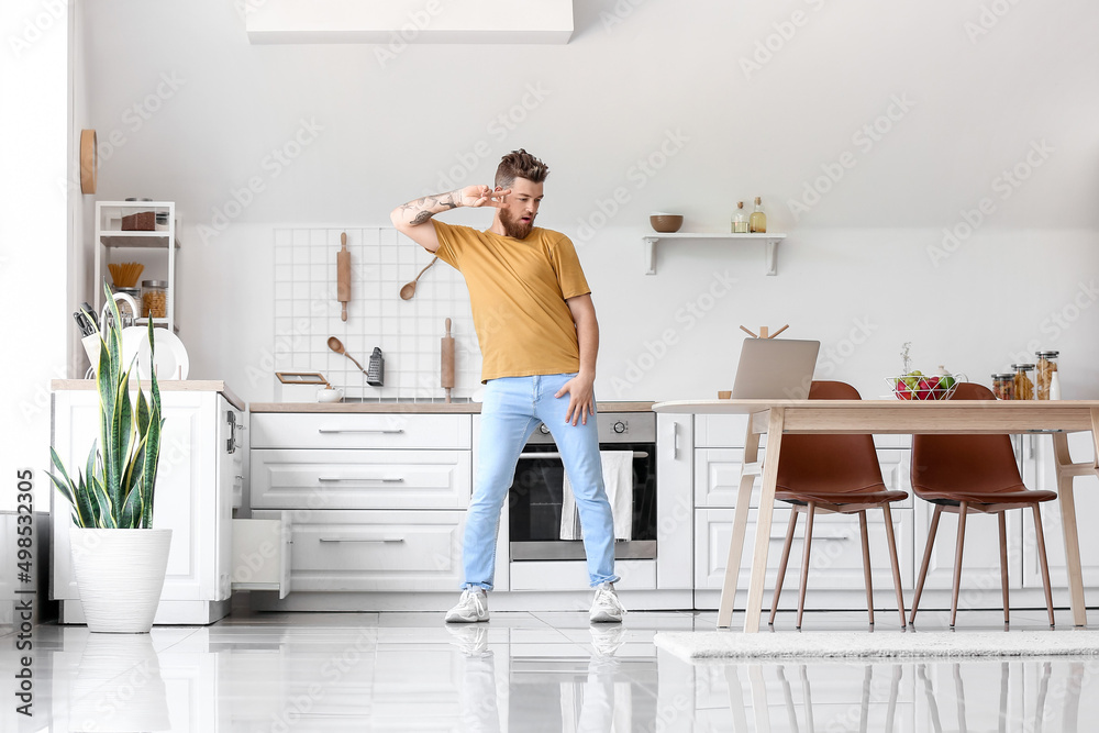 Cool young man with laptop learning to dance at home Cool young man with laptop learning to dance at home