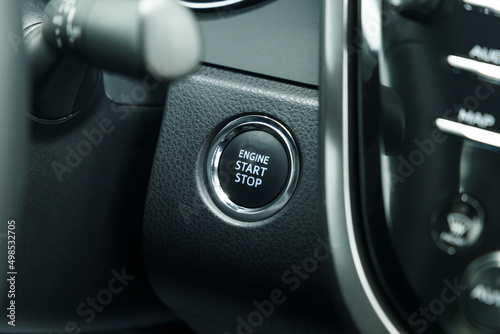 Start stop engine ignition remote starter button of luxury car makes it easy to turn your automobile on and off. Push up button for start or stop car engine in keyless automobile. Close up
