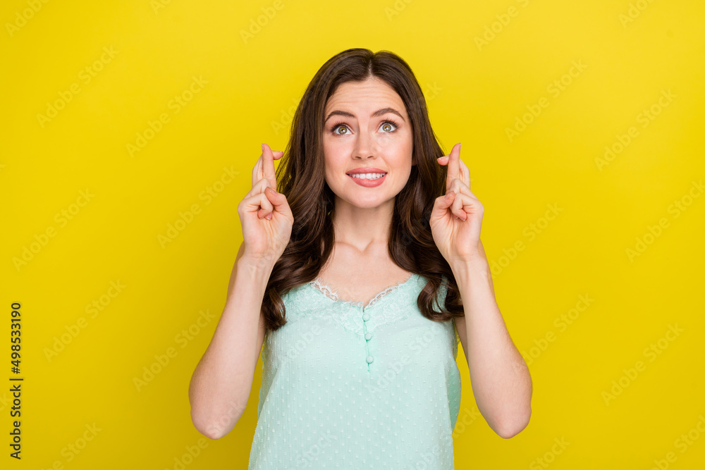 Photo of positive excited dreamy lady with crossed fingers dreaming anticipation isolated on yellow color background Photo of positive excited dreamy lady with crossed fingers dreaming anticipation isolated on yellow color background