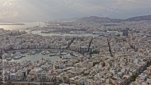 Pireas Greece Aerial v4 drone fly around capturing piraeus and pasalimani harbor bustling bay with a seaport and marina surrounding by beautiful downtown cityscape - September 2021 photo