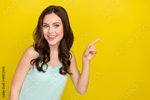 Photo of cute good mood pretty lady recommend shopping season ad promo isolated on yellow color background