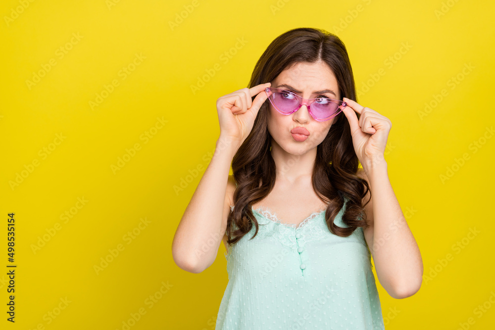Photo of adorable good mood woman look blank space daydreaming wear funky glasses isolated on yellow color background