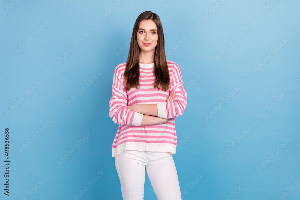 Photo of young satisfied girl crossed hands look camera wear sweater isolated on blue color background Photo of young satisfied girl crossed hands look camera wear sweater isolated on blue color background