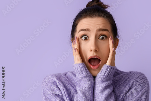 Worried young woman on lila...