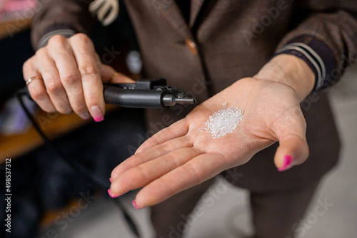 Professional hairdresser holds in his hands hair extension accesories/tools in beaty salon. Pliers and micro tubes.