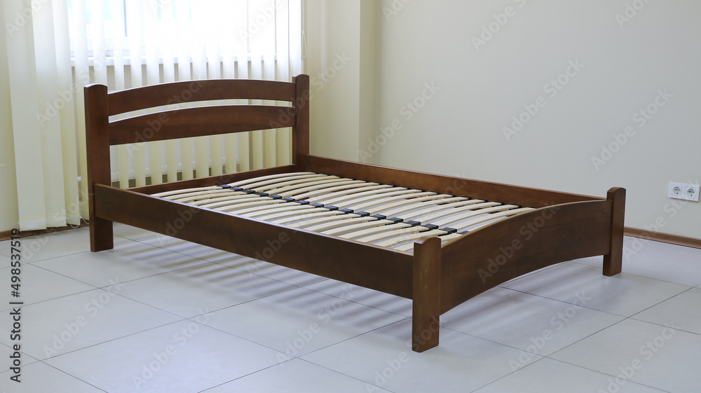 arched wooden bed with slats without mattress
