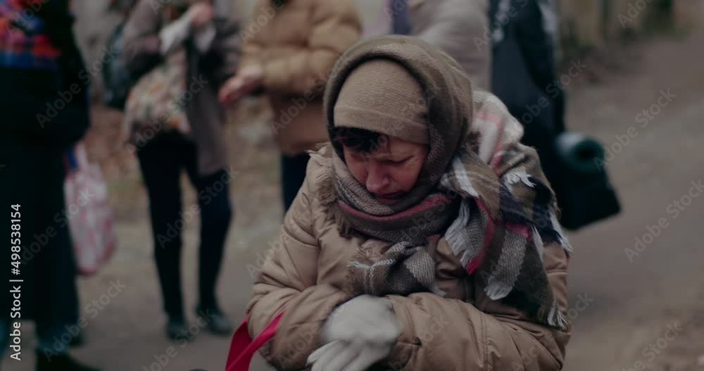 Female Immigrant Rubbing And Praying In Cold During War Crisis. Female Immigrant Rubbing And Praying In Cold During War Crisis.