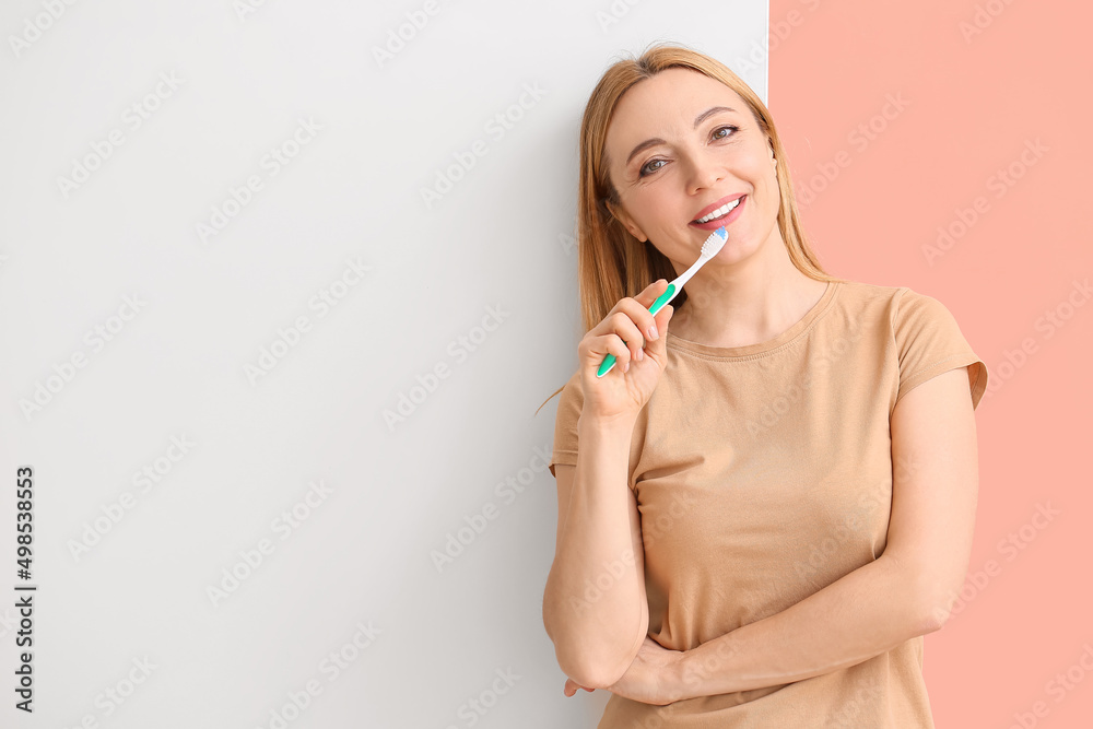 Beautiful mature woman with tooth brush and poster on color background Beautiful mature woman with tooth brush and poster on color background