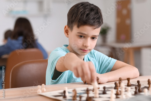 Little boy playing chess du...